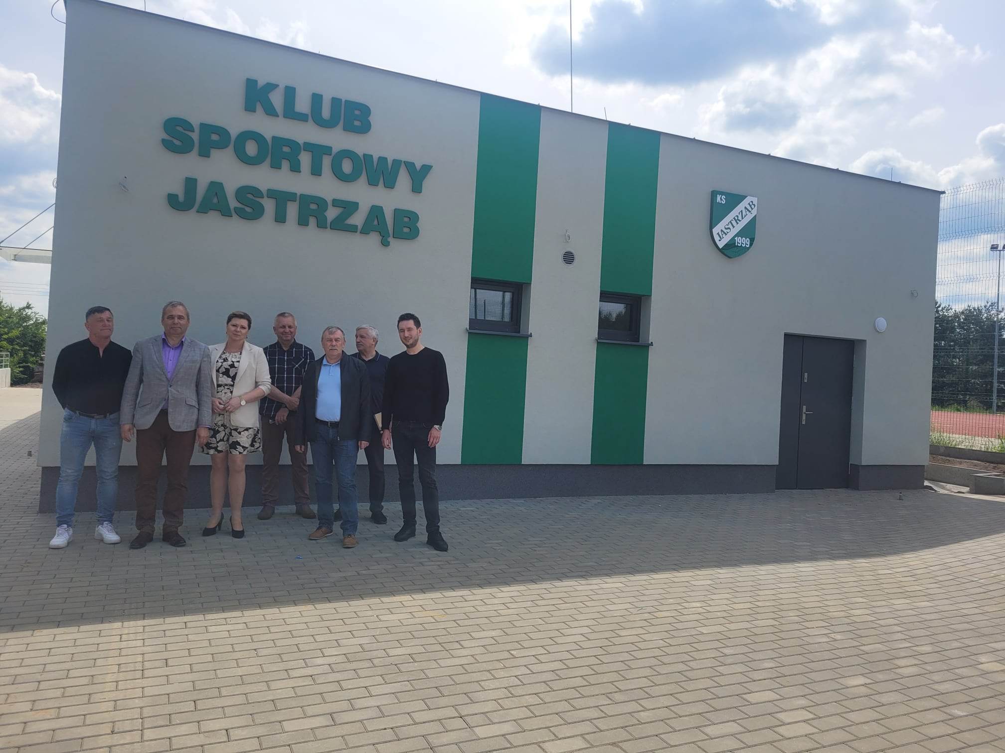 Burmistrz Jastrzębia Andrzej Bracha, Przewodniczący Rady Miejskiej Sławomir Bińkowski, Wiceprzewodniczący Wojciech Warso, Sekretarz Gminy Agnieszka Dąbrowska, pracownicy Urzędu Miejskiego, Wykonawca budowy Paweł Wiatrak z firmy Wiatrobut oraz Inspektorzy Nadzoru przed budynkiem Klubu Sportowego Jastrząb