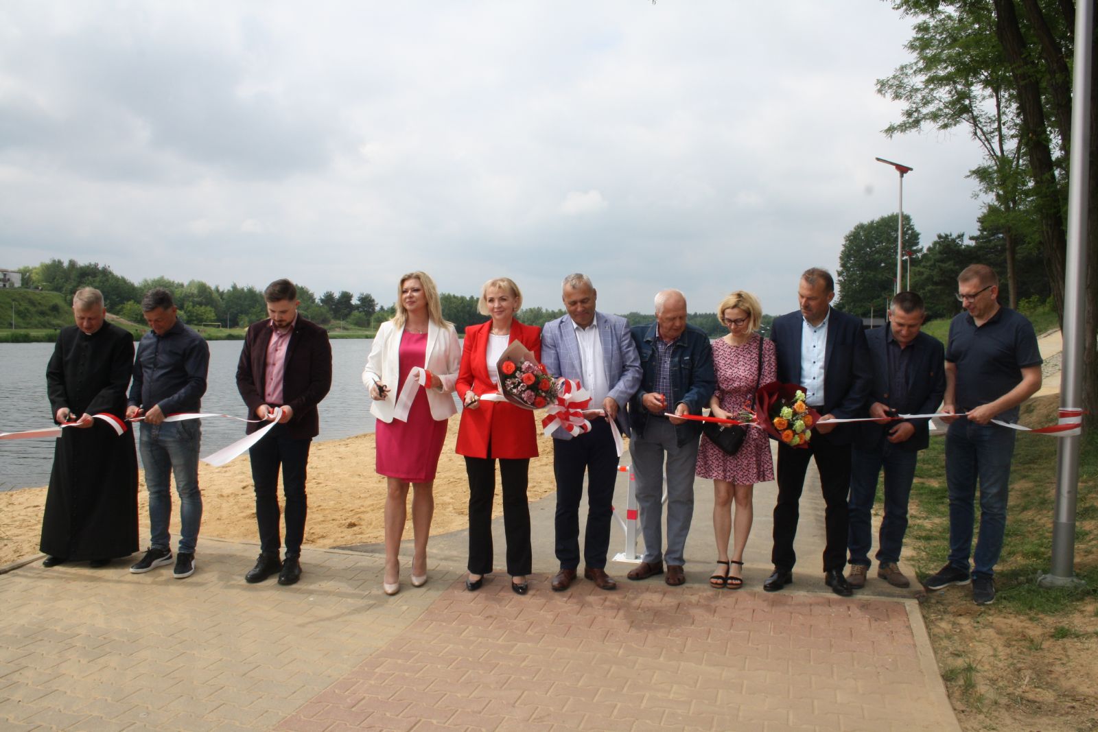 Uczestnicy uroczyście przecinają wstęgę