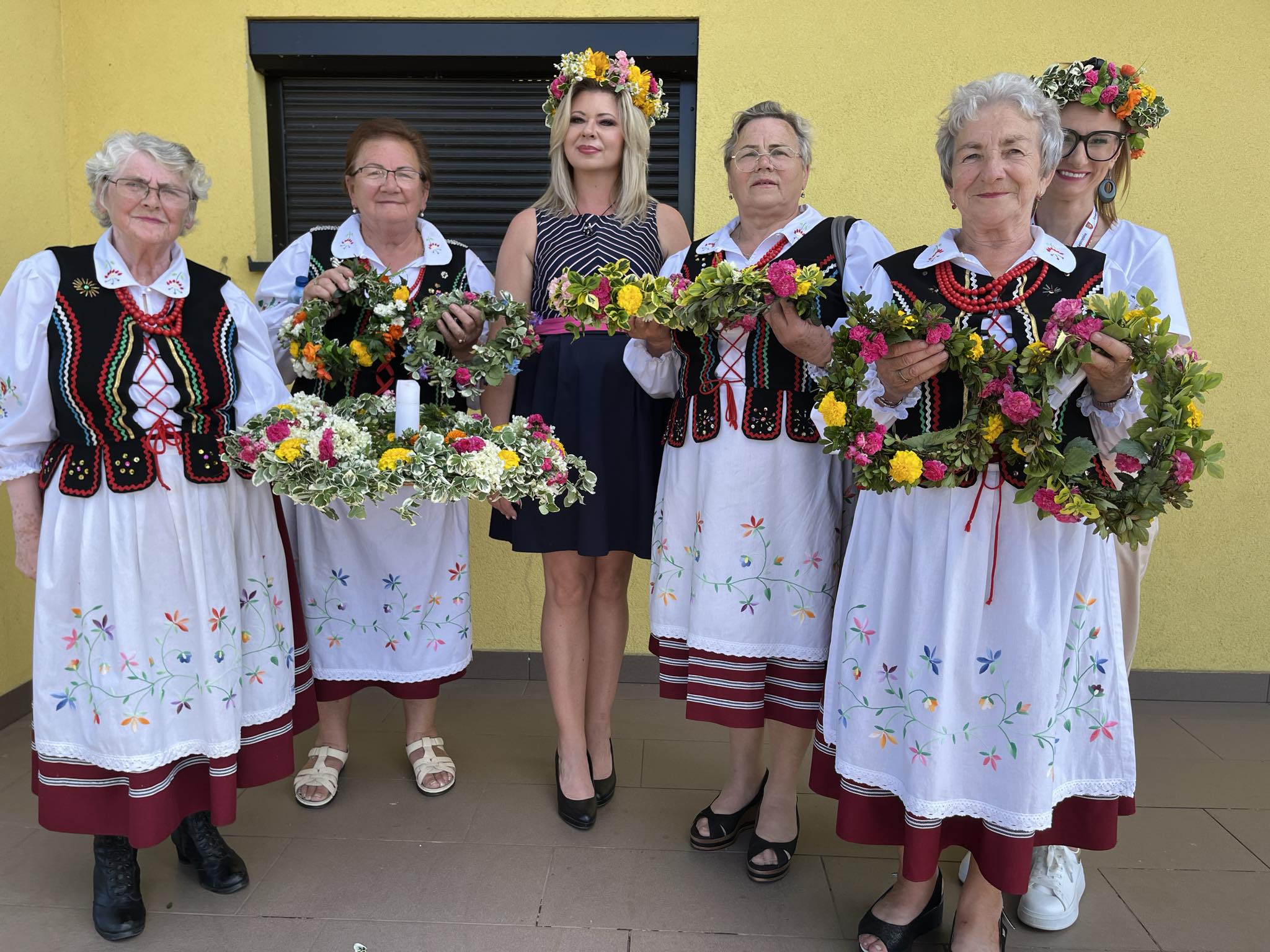 Sekretarz Gminy Agnieszka Dąbrowska oraz Kkobiety w strojach ludowych w wiankach